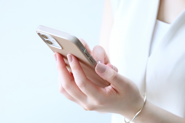スマホをいじっている女性の手元