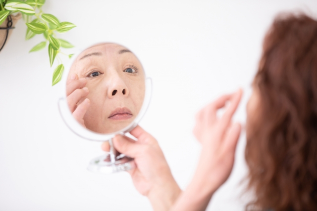 シワを鏡で見て気にする女性