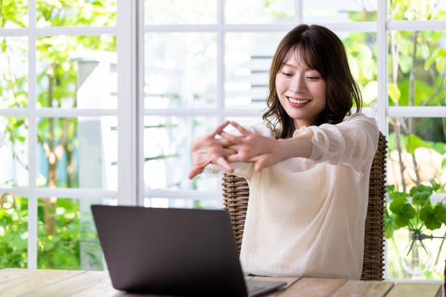 PCの使用を一旦停止してストレッチをする女性