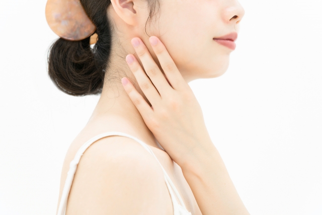 首に手を当てる女性