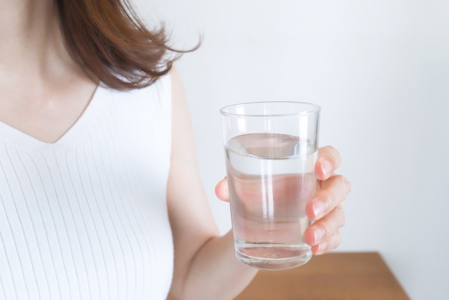 水の入ったコップを持つ女性