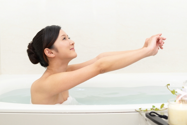 湯舟につかりながら伸びをする女性