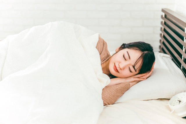 ベッドで心地よく眠りにつく女性
