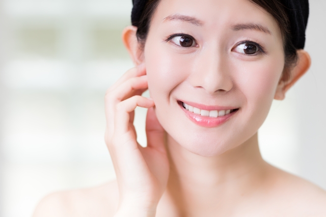 うるおい肌に満足して微笑みを浮かべる女性